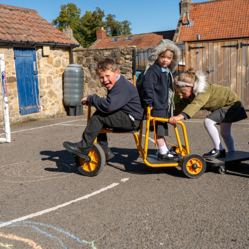 Children playing outside on trikes 